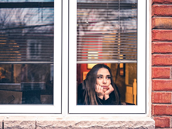 Girl looking out of window during the pandemic